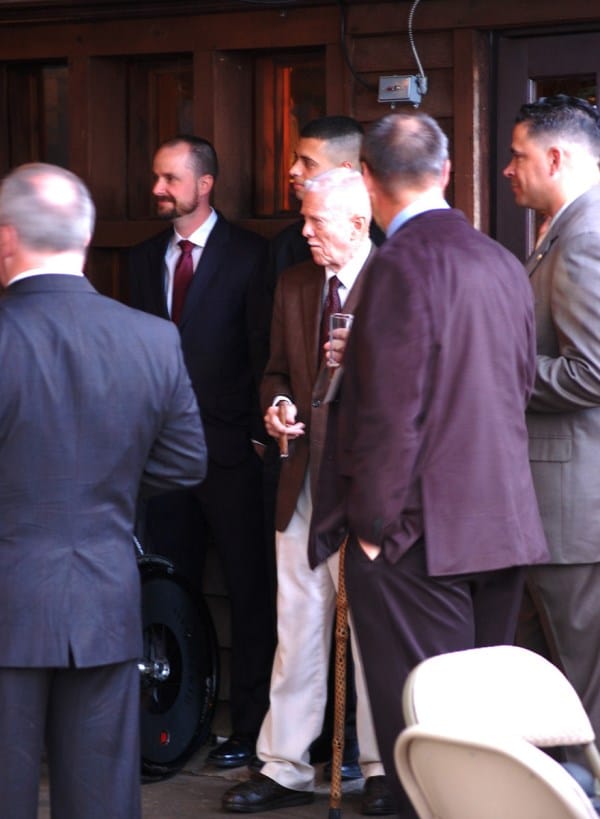 Maj Rick Spooner, USMC (Ret) (center with cigar), owner of the host facility, the Globe and Laurel Restaurant listens to the presentation